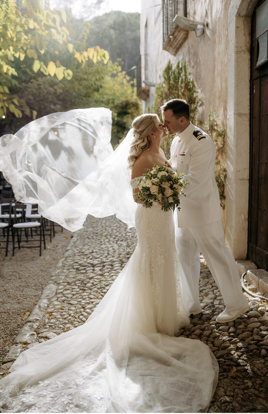 Couple on a cobbled path with the veil caught in the wind