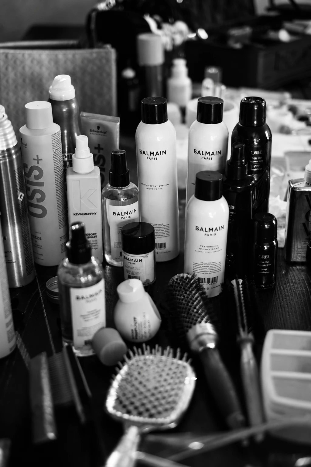 Hair styling products and brushes on a table, black and white